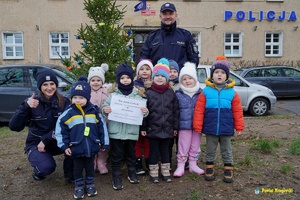 zdjęcie grupowe dzieci i policjantki i policjanta przed choinką