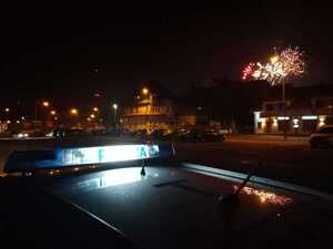 dach policyjnego radiowozu i fajerwerki w tle