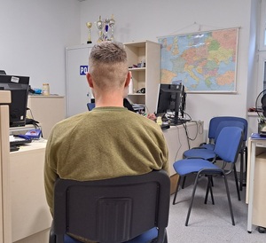 siedzący na krześle tyłem mężczyzna