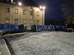 dach policyjnego radiowozu a w tle budynek komendy