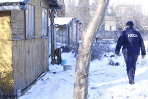 policjant chodzący przy altankach zimą