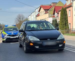 zdjęcie samochodu osobowego i stojącego za nim radiowozu
