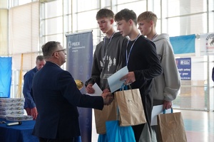 starosta wręcz puchar stojącym na podium uczniom