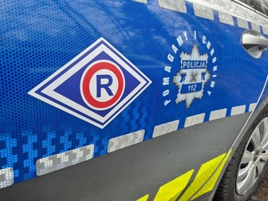 bok radiowozu z logo ruchu drogowego oraz napis pomagamy i chronimy