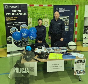 policjantka i policjant przy stoisku promującym zawód policjanta