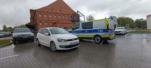 stojące na parkingu samochody osobowe i radiowóz