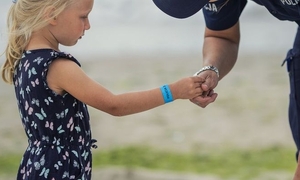 policjant trzymający za dłoń dziecko