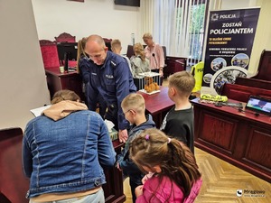 na sali policjant oraz osoby zwiedzające sąd
