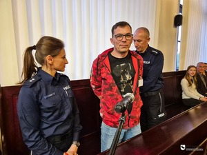 stojąca policjantka obok niej aktor grający oskarżonego oraz policjant