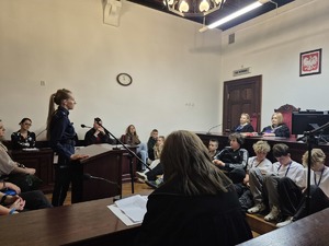 policjantka stojąca przed ławą sędziowską