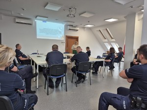 siedzący na sali policjanci i stojąca przed nimi Sędzia Sądu Rejonowego w Mrągowie