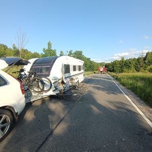 pojazd stojący na drodze z udzkodzoną przyczepą campingową