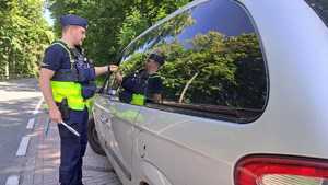 policjant sprawdzający trzeźwość kierowcy samochodu osobowego