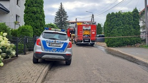 stojący na podjeździe radiowóz i wóz strażacki