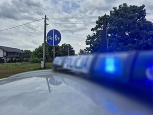 dach radiowozu a w tle znak droga pieszo rowerowa