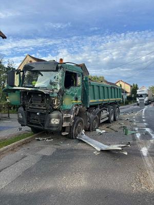 ciężarówka z rozbitą kabiną i bokiem stojąca na drodze