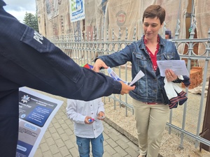policjantka wręcz ulotki o bezpieczeństwie rodzicom