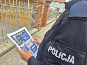 policjantka trzyma ulotki o bezpieczeństwie