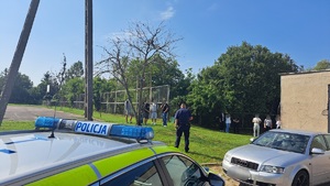 policjant idący w kierunku grupy młodzieży