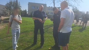 dwóch policjantów rozmawia z 2 chłopcami i mężczyzną
