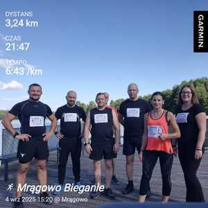 policjanci po cywilnemu ubrani stoją na molo. Na ubraniach mają naklejony numerek startowy