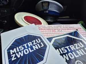 ulotki z napisem Mistrzu zwolnij, tarcza do zatrzymywania pojazdów i bloczek mandatowy