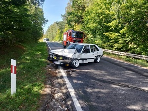 biały samochód marki polonez stojący w poprzek drogi za nim wóz strażacki