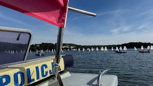 dach łodzi policyjnej a w tle żaglówki na jeziorze