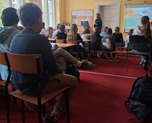 policjantka stoi przed siedzącymi uczniami