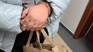 ręce kobiety z założonymi kajdankami