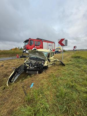 w rowie przydrożnym rozbity samochód osobowy a na drodze stojący wóz strażacki