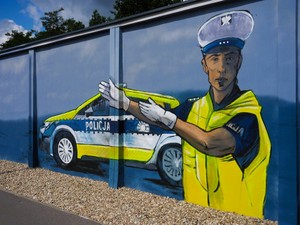 Na zdjęciu widać namalowany na murze mural przedstawiający policjanta ruchu drogowego i radiowóz