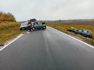 Stojący na drodze rozbity samochód osobowy a w rowie kolejny rozbity samochód