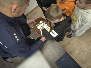 komendant wręcza dzieciom odblaski