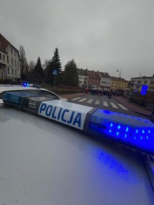 na pierwszym planie radiowóz a w tle uczestnicy Marszu Niepodległości