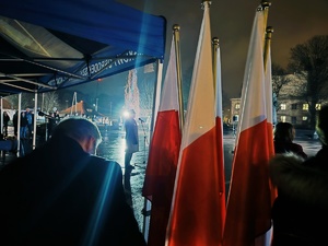 na pierwszym planie flagi a w tle plac apelowy