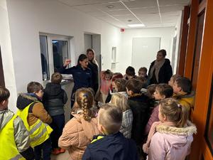 dzieci zwiedzają budynek KPP Mrągowo, policjantka pokazuje im stanowisko kierowania