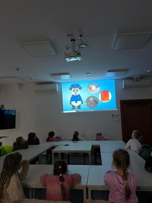 dzieci na sali odpraw oglądają edukacyjną bajkę