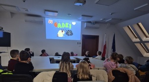 dzieci na sali odpraw oglądają edukacyjną bajkę