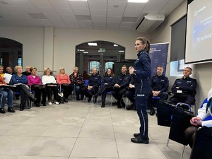 policjantka stojąca na sali przed słuchaczami