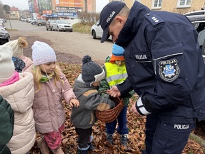 dzieci z policjantami ubierają odblaskami choinkę
