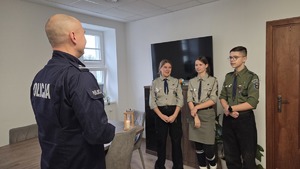 Komendant rozmawia z 2 harcerkami i 1 harcerzem