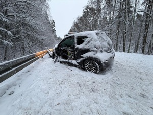 samochód osobowy zaśnieżony, rozbity przy barierce, bez drzwi od strony kierowcy