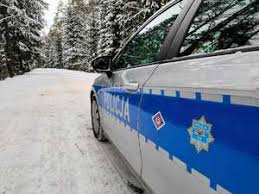 radiowóz na zaśnieżonej drodze w lesie