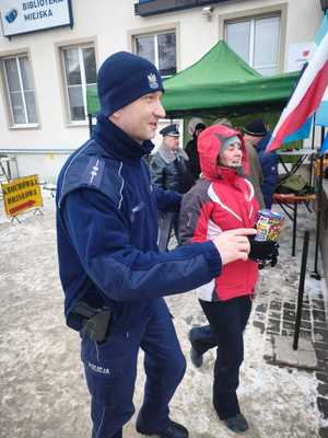 policjant idzie z kobietą kwestującą
