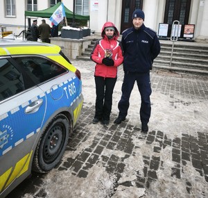 policjant stoi obok kwestującej kobiety
