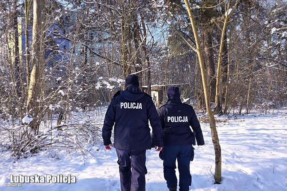 policjanci zimą idą w kierunku pustostanu