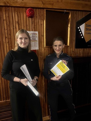 policjantka i pracownik urzędu z ulotkami i odblaskami