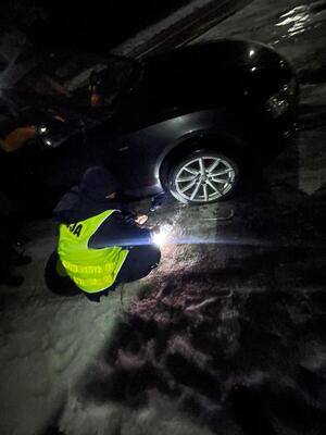 Zdjęcia przedstawia policjanta wymieniającego koło.