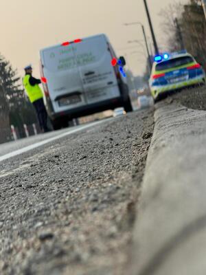 Zdjęcie przedstawia policjanta przeprowadzającego badanie na zawartość alkoholu na drodze.